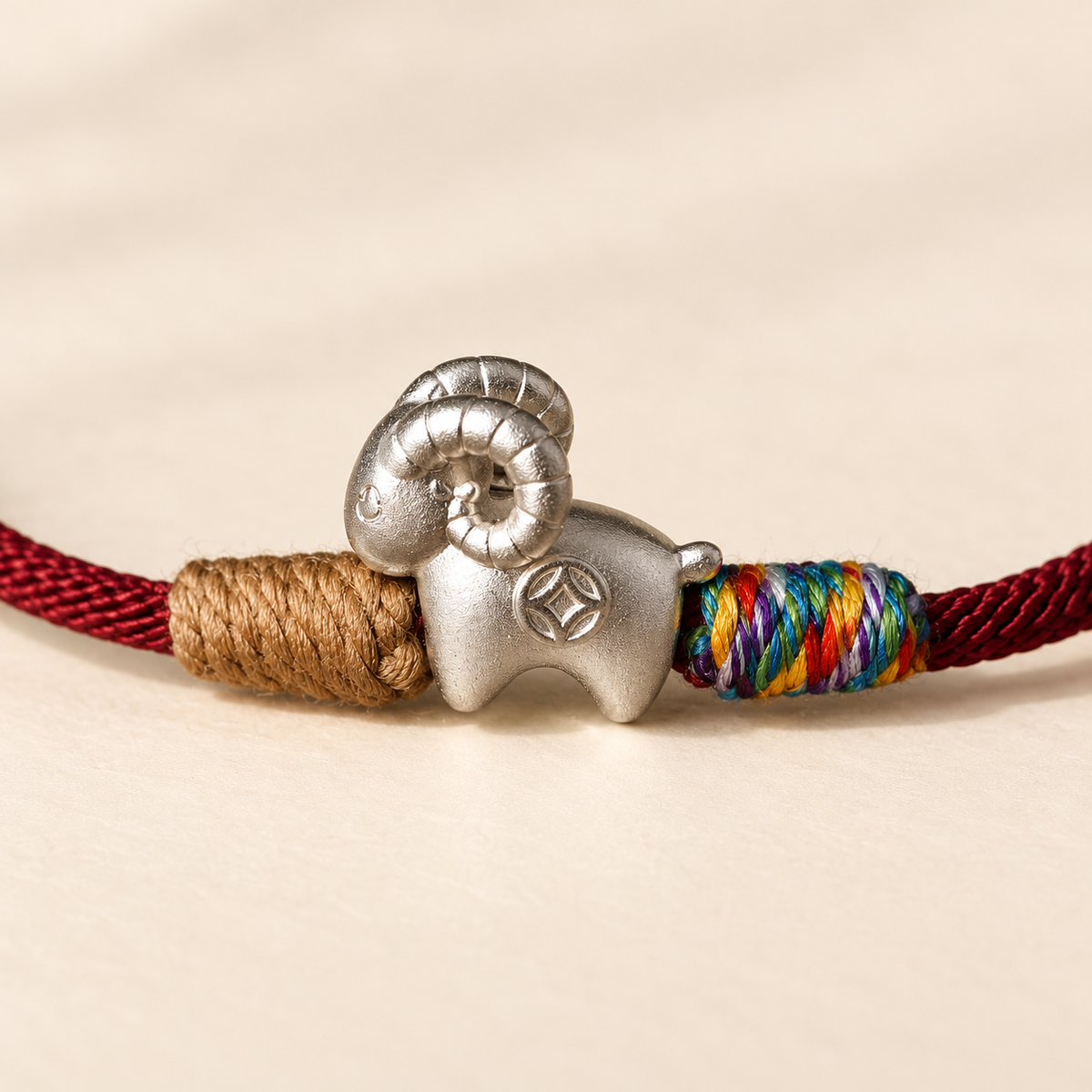 Close view of the curled horns and coin detail on the silver goat bracelet #cord color_burgundy