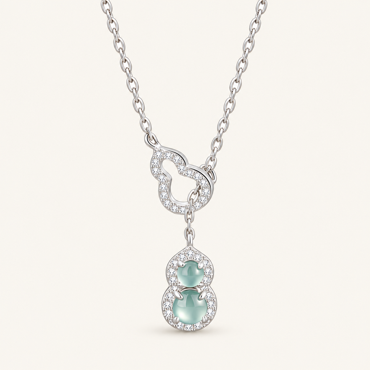 Green Jade Gourd Pendant with Silver Setting on an ivory background