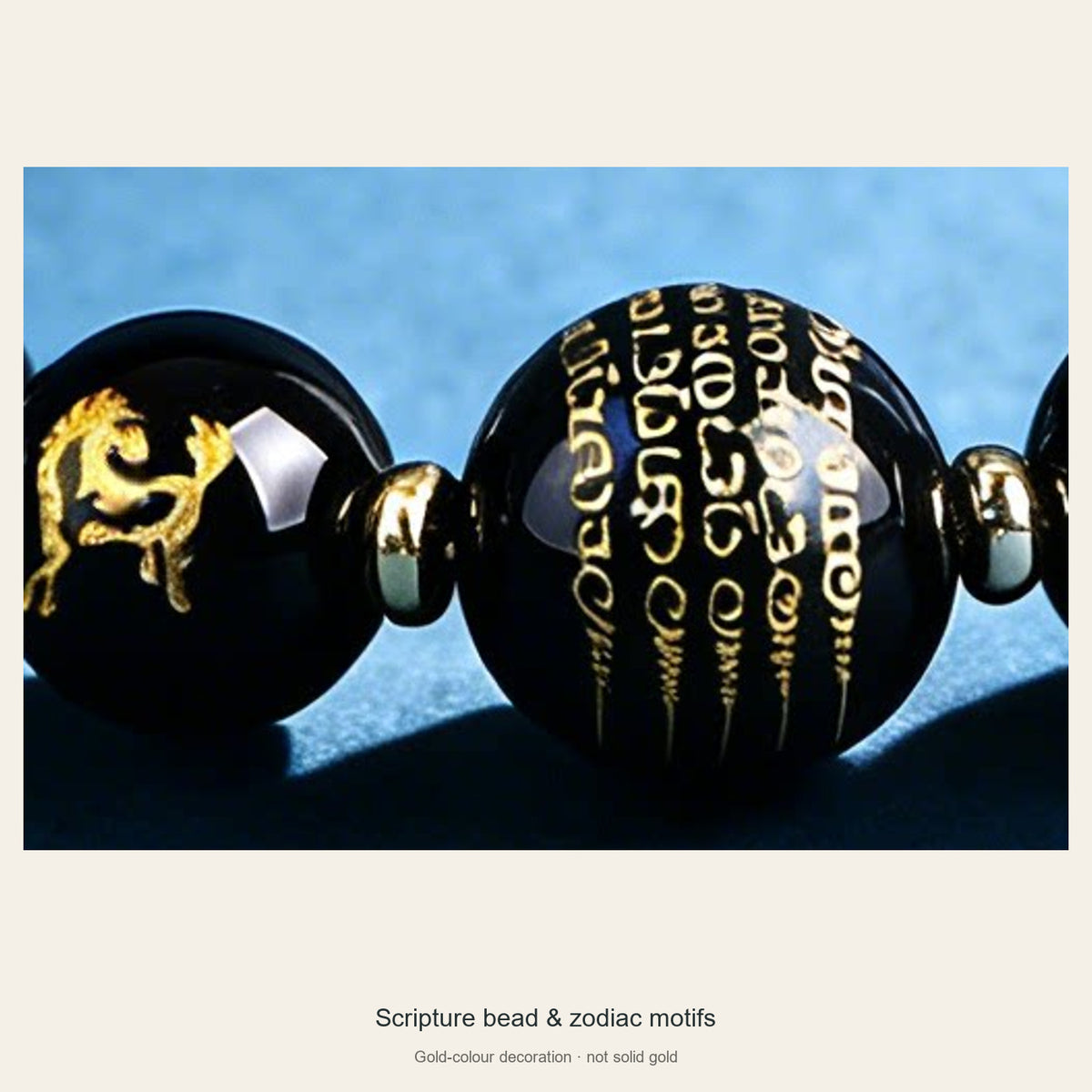 Close-up of central scripture bead and gold-colour animal motifs